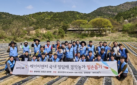 The photo shows KT&G employees taking a group photo during the volunteer activity.