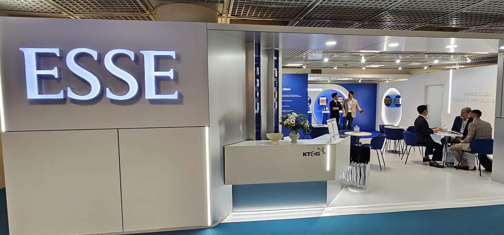 KT&G’s booth can be seen in the photograph above.,KT&G’s exhibition staff is seen briefing a duty-free stakeholder visiting the booth.