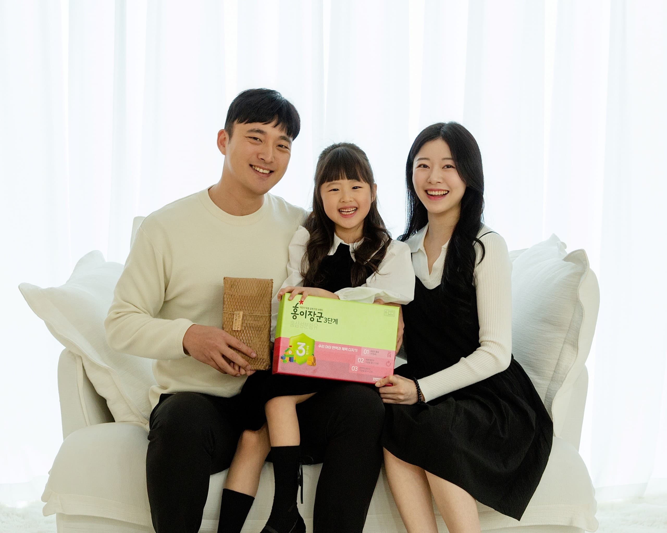 The photo shows a KT&G employee and their family posing for a commemorative photo after receiving a